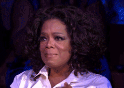 Animated GIF of Oprah Winfrey holding back tears, nodding affirmatively and biting her lip.